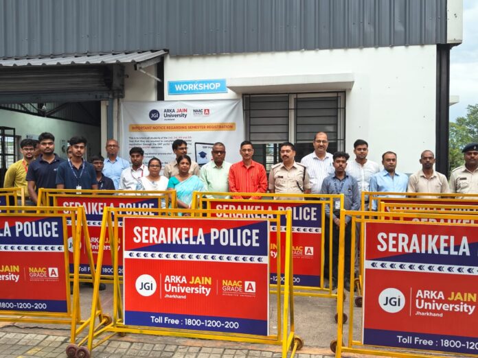 अरका जैन यूनिवर्सिटी के छात्र ट्रैफिक पुलिस को बैरियर सौंपते हुए